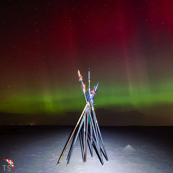 Polarlichter am Strand mit Stangen für Fischernetze